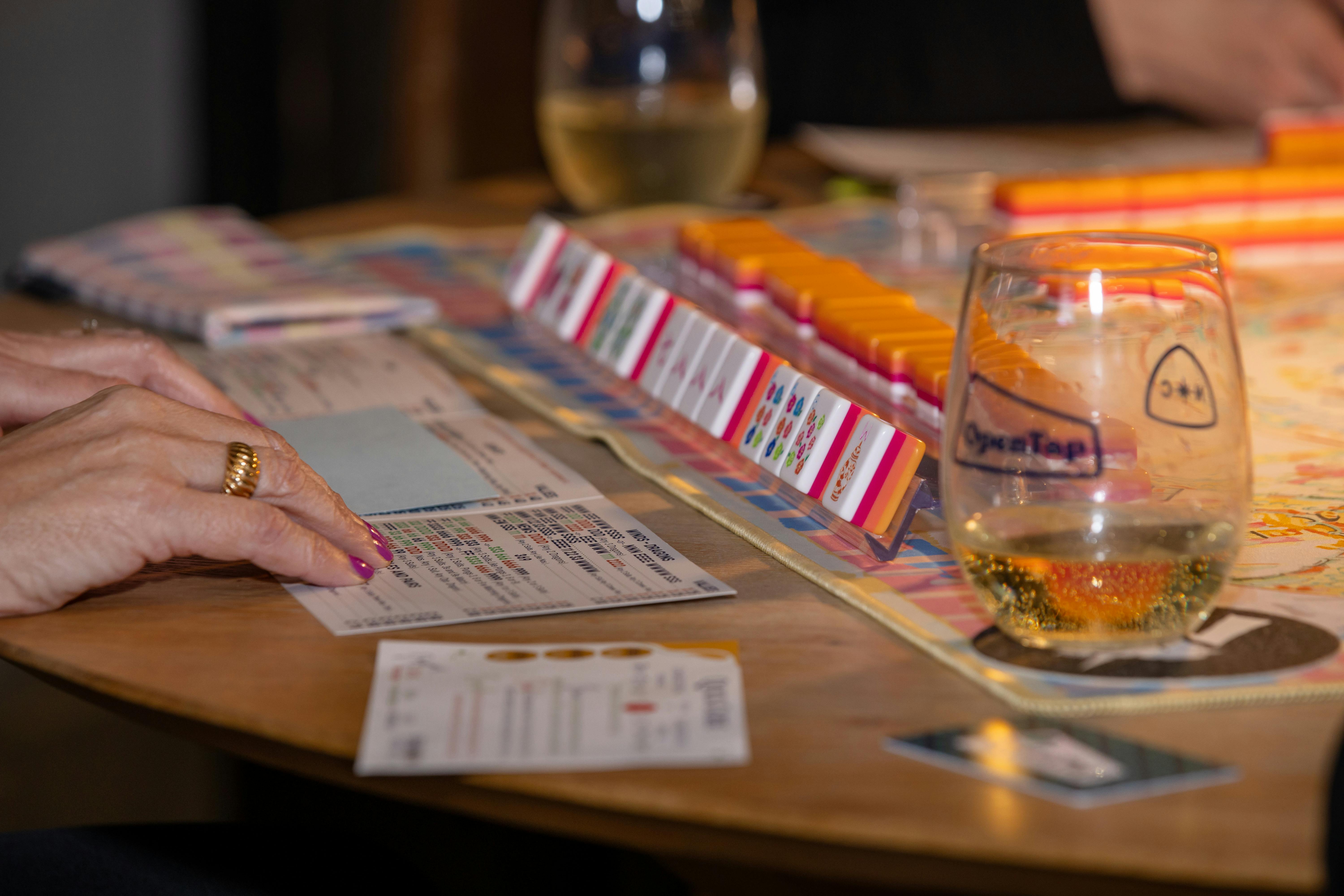Adults around a table in an intense competitive board game session with cards and tokens visible